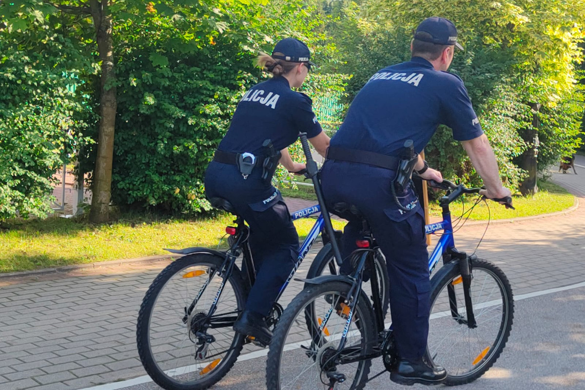 Dwoje policjantów jadących rowerami po ścieżce rowerowej