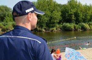 Policjant na tle jeziora i lasu