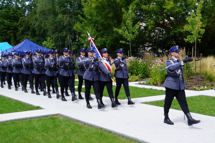 Przemarsz Kompanii Honorowej. Policjanci ze sztandarem idący w kolumnie