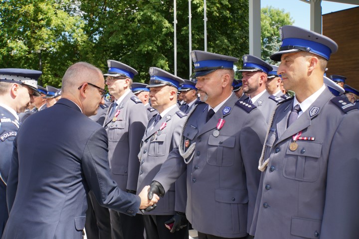 Minister Spraw Wewnętrznych i Administracji odznacza medalem policjanta medalem stojącego w szeregu