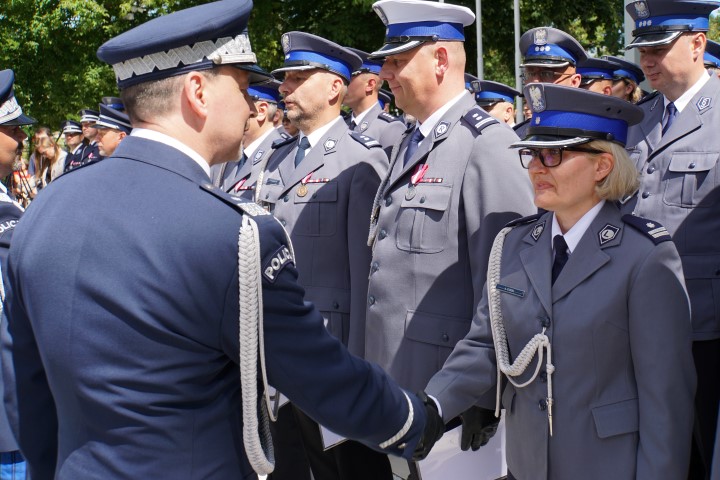 Awansowany policjant odbiera akt mianowania i gratulacje od komendanta