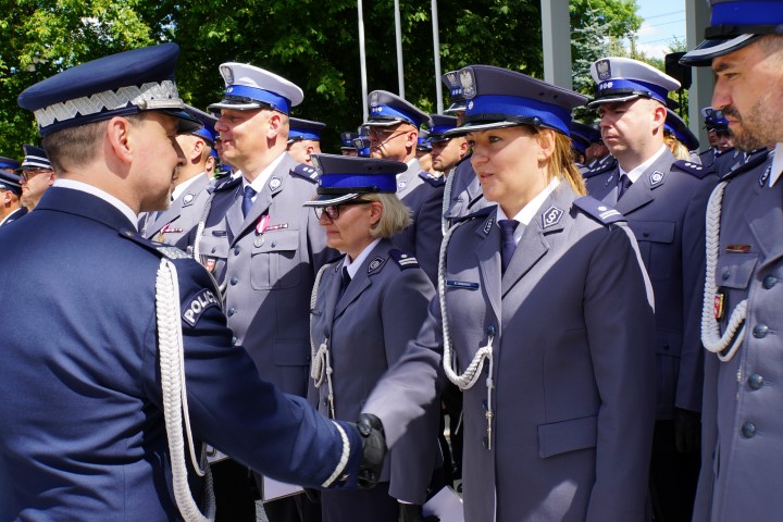 Awansowany policjant odbiera akt mianowania i gratulacje od komendanta