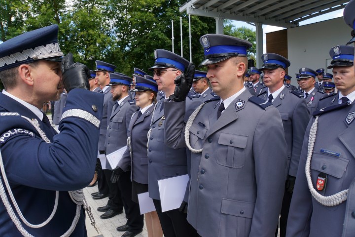 Awansowany policjant odbiera akt mianowania i gratulacje