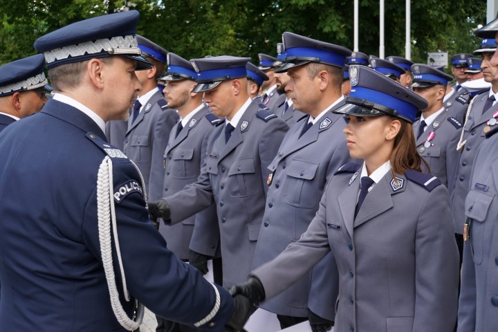 Awansowany policjant odbiera akt mianowania i gratulacje