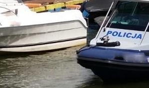 Policyjna łódka na wodzie obok innej łodzi
