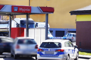 Radiowóz i inne samochody przy budynku myjni samochodowej