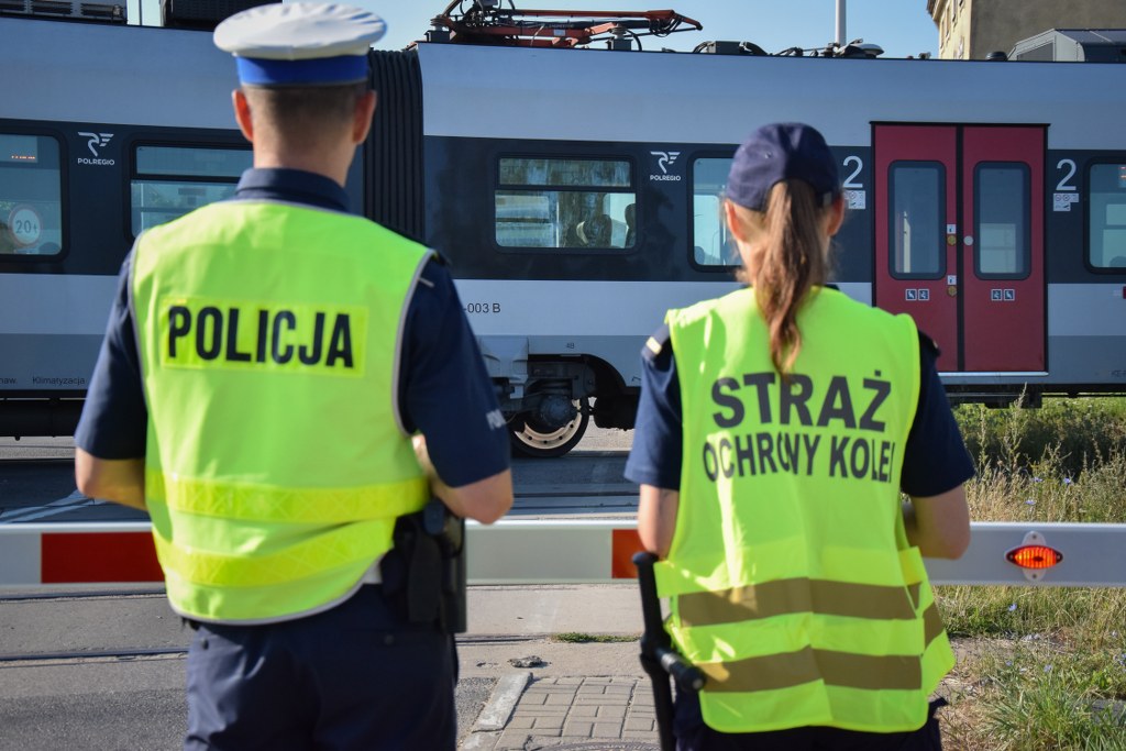 Policja i funkcjonariuszka SOK podczas działań przed przejazdem kolejowym