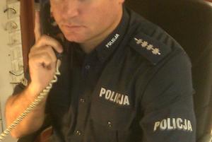policjant trzymający w ręku słuchawkę