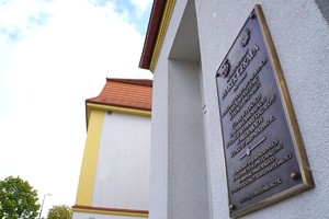 Pamiątkowa tablica na ścianie budynku