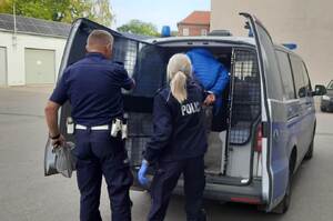 Poszukiwany osadzany w radiowozie przez policjantów