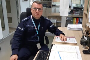 asp. szt. Krzysztof Zaręba siedzący za biurkiem