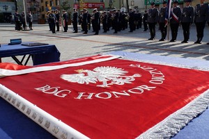 Sztandar leżący na stole i policjanci w tle