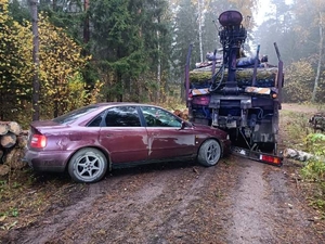 Rozbity samochód osobowy, stojący przy pojeździe ciężarowym, w który uderzył na leśnej drodze