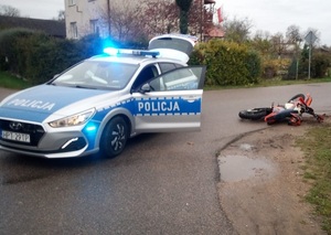 Policyjny radiowóz i przewrócony na drodze motocykl crossowy