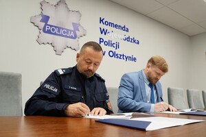 nadinsp. Tomasz Klimek Komendant Wojewódzki Policji w Olsztynie oraz Patryk Kozłowski Dyrektor Muzeum Pogranicza w Działdowie podpisują porozumienie siedząc za stołem