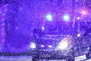 Radiowóz w nocy podczas śnieżycy