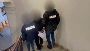 policjanci prowadzą osobę zatrzymaną