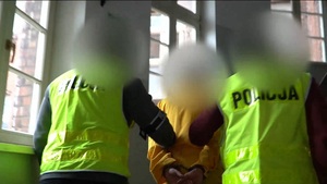 Zatrzymany mężczyzna prowadzony przez policjantów