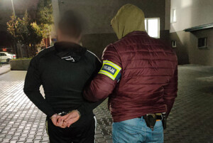 Zatrzymany mężczyzna prowadzony przez policjanta