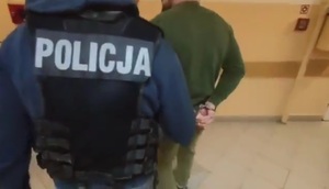 policjant prowadzi zatrzymanego