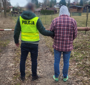 Policjant prowadzi zatrzymanego