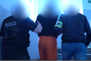 Zatrzymany mężczyzna prowadzony przez policjantów
