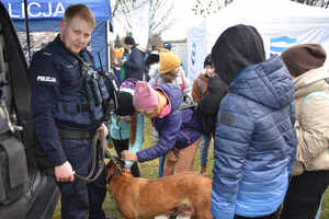 Uczestnicy festynu. Wśród nich policjant z psem służbowym