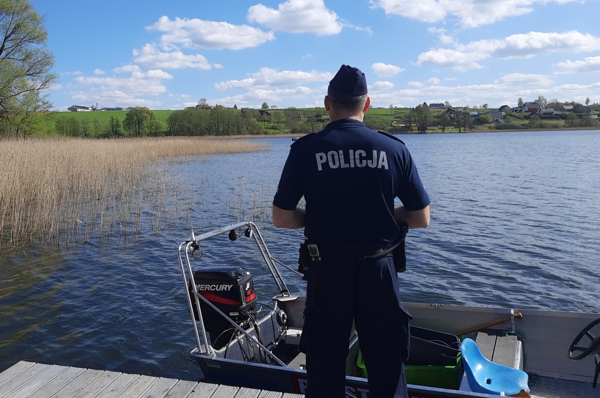 Policjant stojący na pomoście nad jeziorem