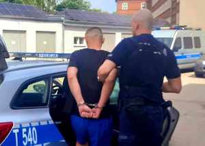 Policjant prowadzi zatrzymanego