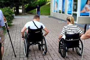 Uczestnicy zajęć jadący wózkami inwalidzkimi