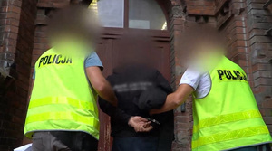 Zatrzymany mężczyzna prowadzony przez policjantów