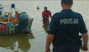 policjant i strażacy na brzegu jeziora