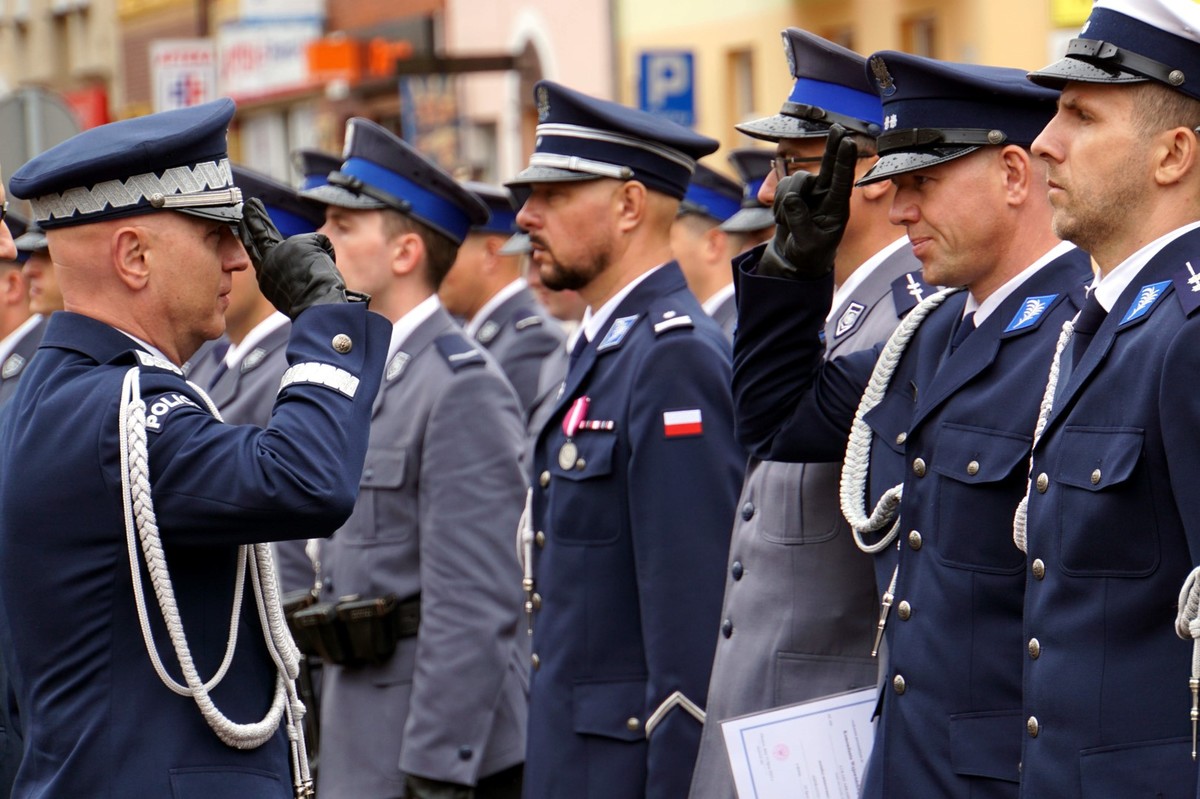 Wręczenie przez generała awansu policjantowi stojącemu w szeregu