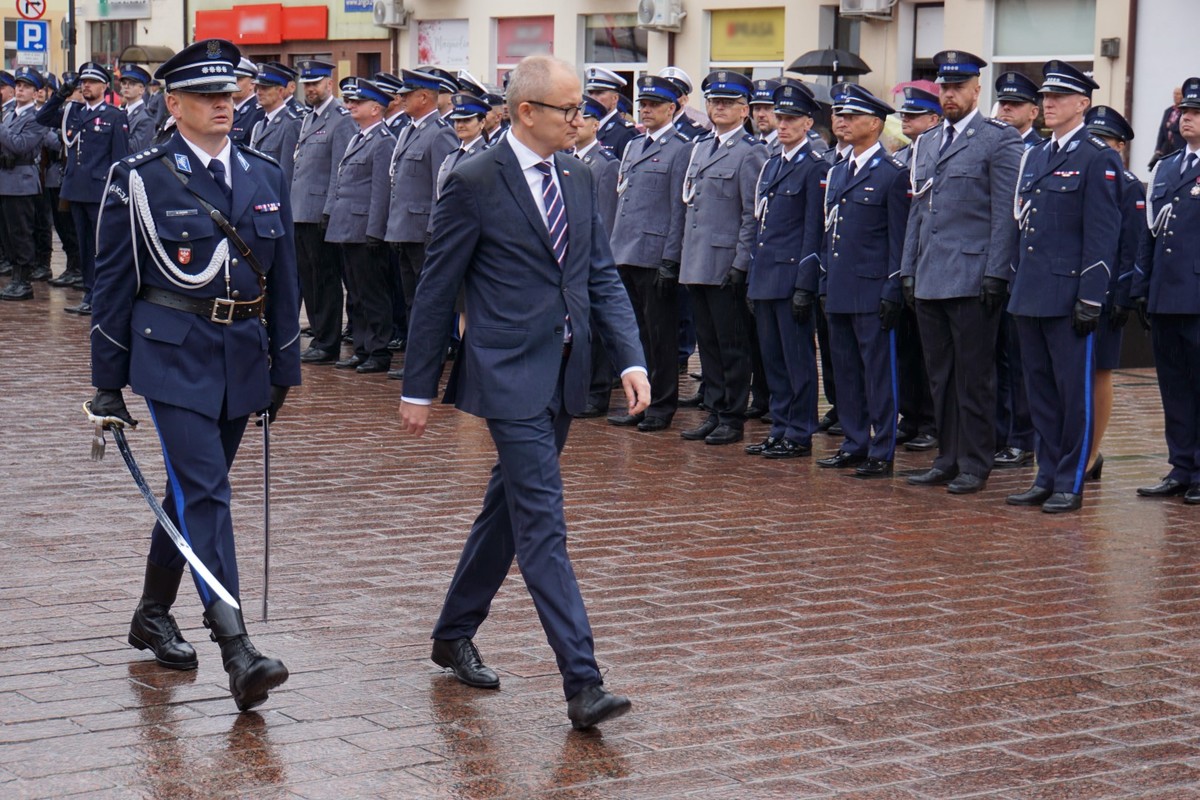 Błażej Poboży Podsekretarz Stanu MSWiA idący przed szeregiem policjantów