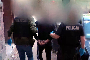 Zatrzymany mężczyzna prowadzony przez policjantów