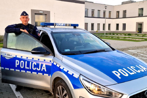 st. sierż. Patryk Rutkowski przy radiowozie