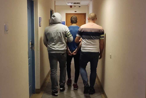Zatrzymany mężczyzna prowadzony przez policjantów