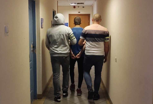 Zatrzymany mężczyzna prowadzony przez policjantów