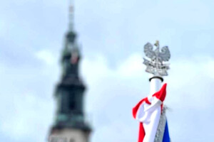 Policyjny sztandar na tle kościelnej wierzy