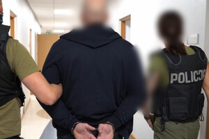 Zatrzymany mężczyzna prowadzony przez policjantów