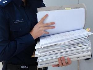 Policjant trzymający teczkę z aktami