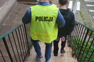 Zatrzymany mężczyzna prowadzony przez policjanta