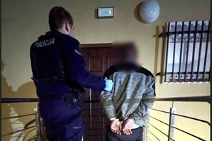 Zatrzymany mężczyzna prowadzony przez policjanta