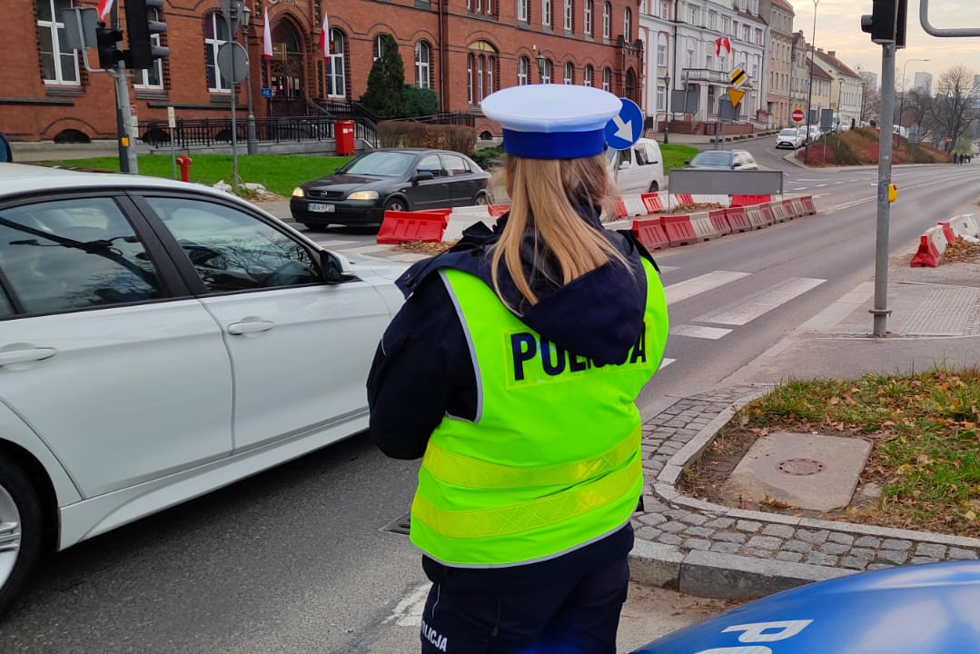 Policjantka podczas służby stojąca przy drodze