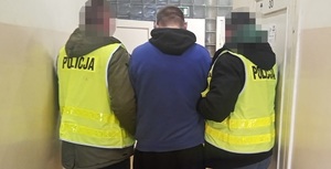 Zatrzymany mężczyzna prowadzony przez policjantów