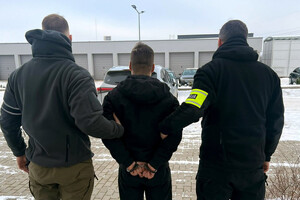 Zatrzymany mężczyzna prowadzony przez policjantów