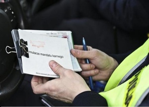 Bloczek mandatowy w dłoni policjanta