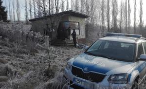 Radiowóz i szopa w tle w zimowej aurze