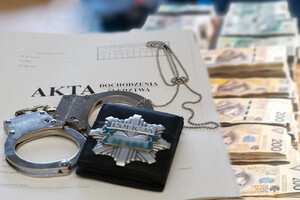 Teczka z aktami i kajdanki oraz banknoty w tle