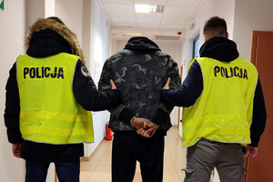 Zatrzymany mężczyzna prowadzony przez policjantów
